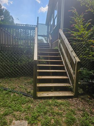 steps up to the deck of a house with a fence