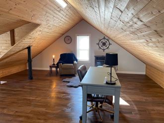 an attic office with a desk and chair and a window