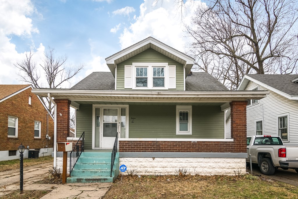 a green house with a truck parked outside of it