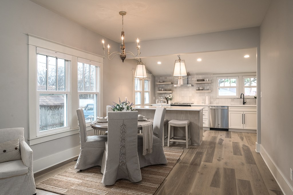 a kitchen and dining room with white cabinets and a table and chairs