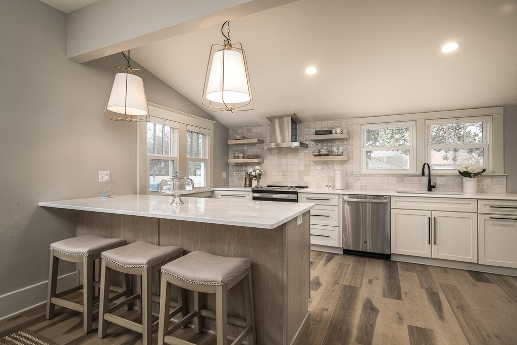 a kitchen with a large island with three stools