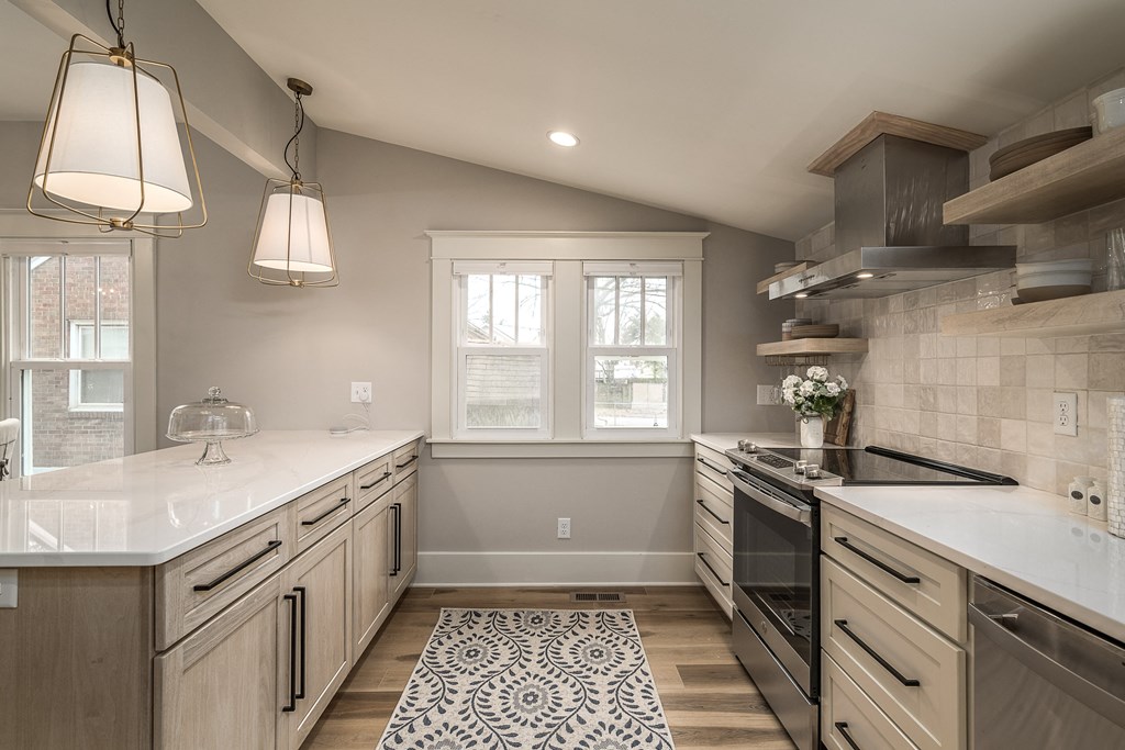 a kitchen with white counter tops and wooden floors