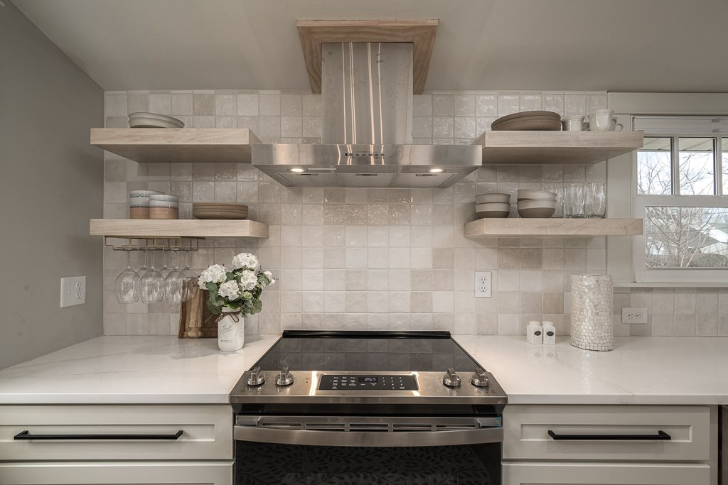 a view of a kitchen with a stove and counter tops