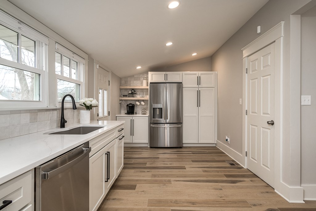a kitchen with white cabinets and a stainless steel refrigerator