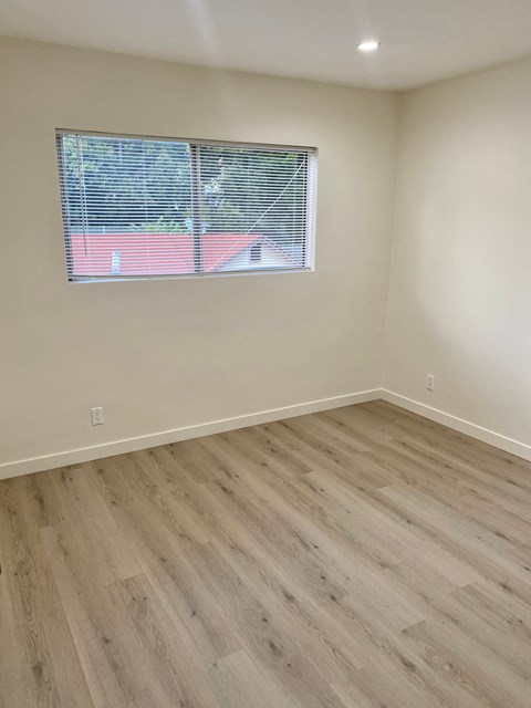 A room with a window and wooden flooring.