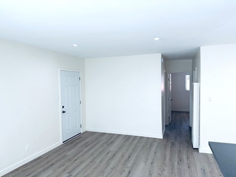 A room with a white door and a grey rug.
