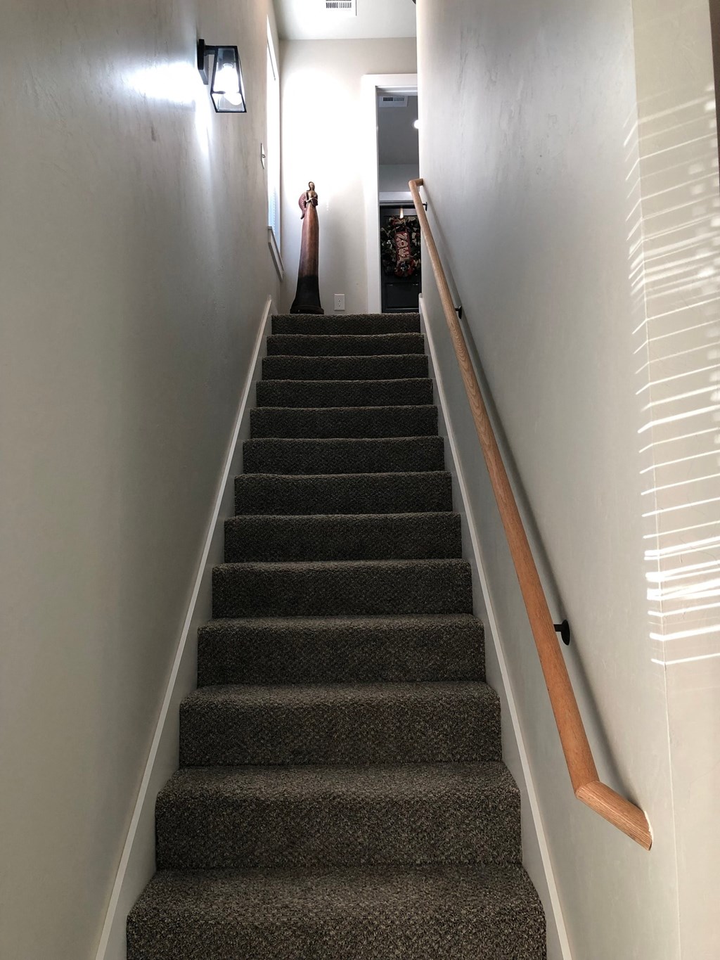 a flight of stairs leading up to a hallway with a wooden railing and a guitar