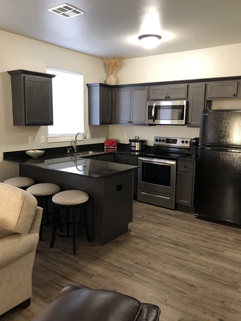 a view of a kitchen and a living room with a table and chairs