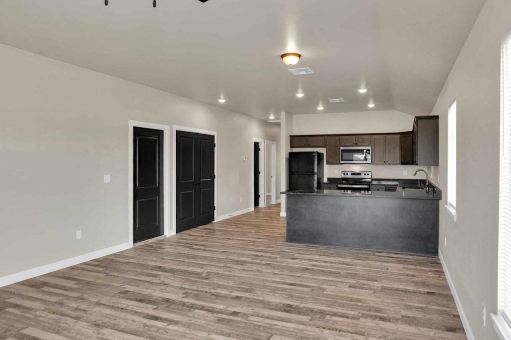a kitchen and living room with a counter and a refrigerator and a sink