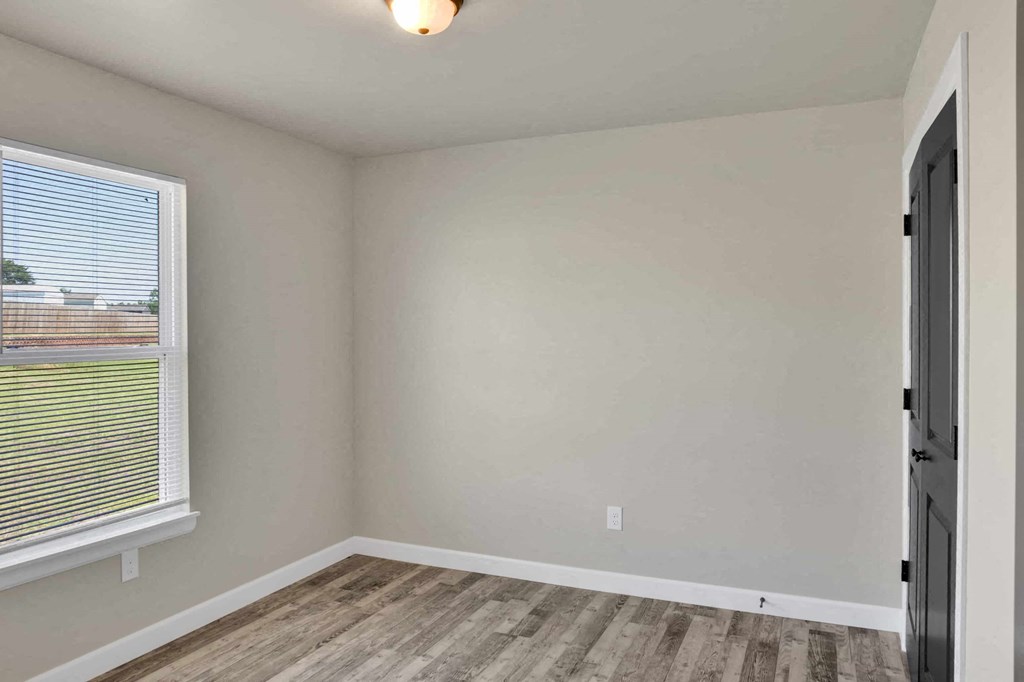 an empty room with a window and a door