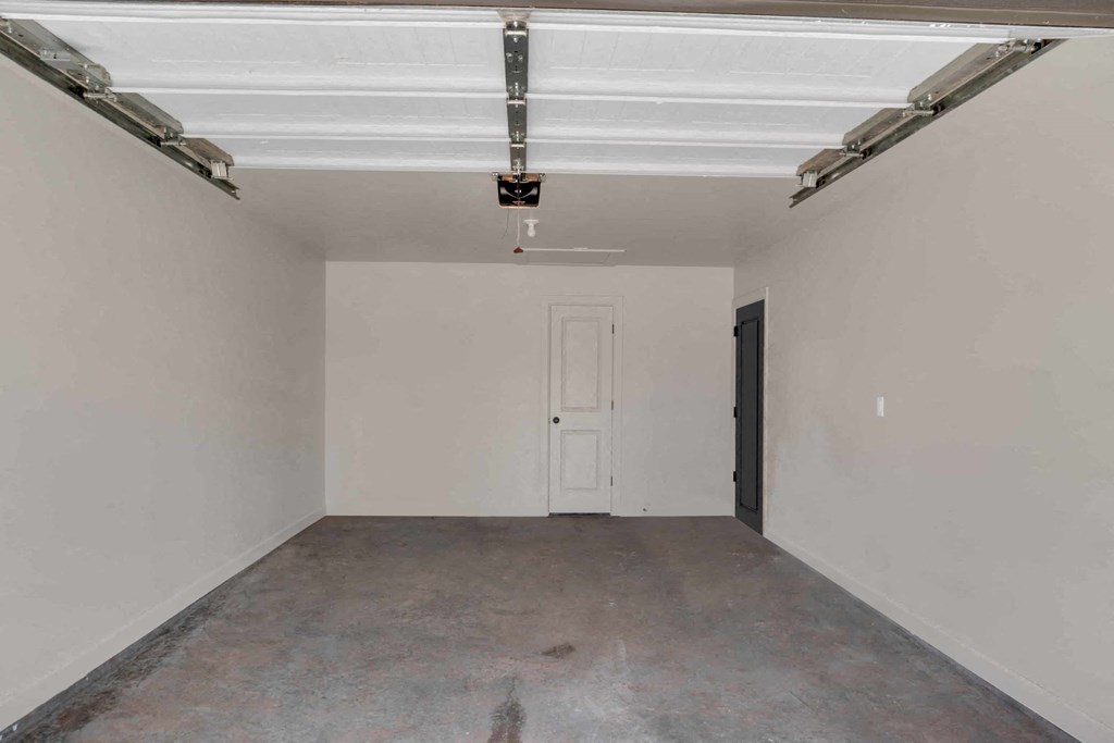 an empty garage with white walls and a white door