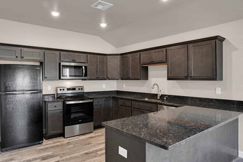 a kitchen with black appliances and granite counter tops