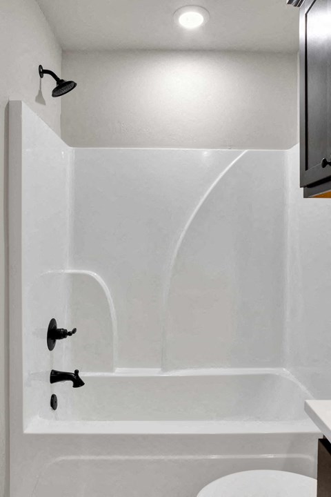 a white bathroom with a tub and a sink