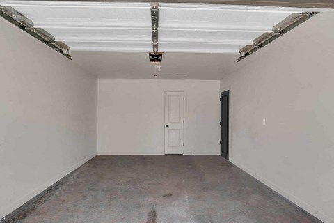 an empty garage with white walls and a white door