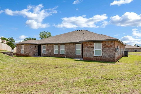 an old brick house sitting in a grassy field