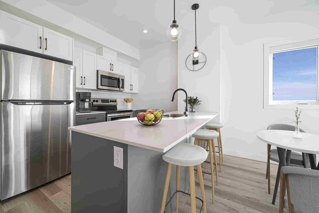 a kitchen with stainless steel appliances and a marble counter top