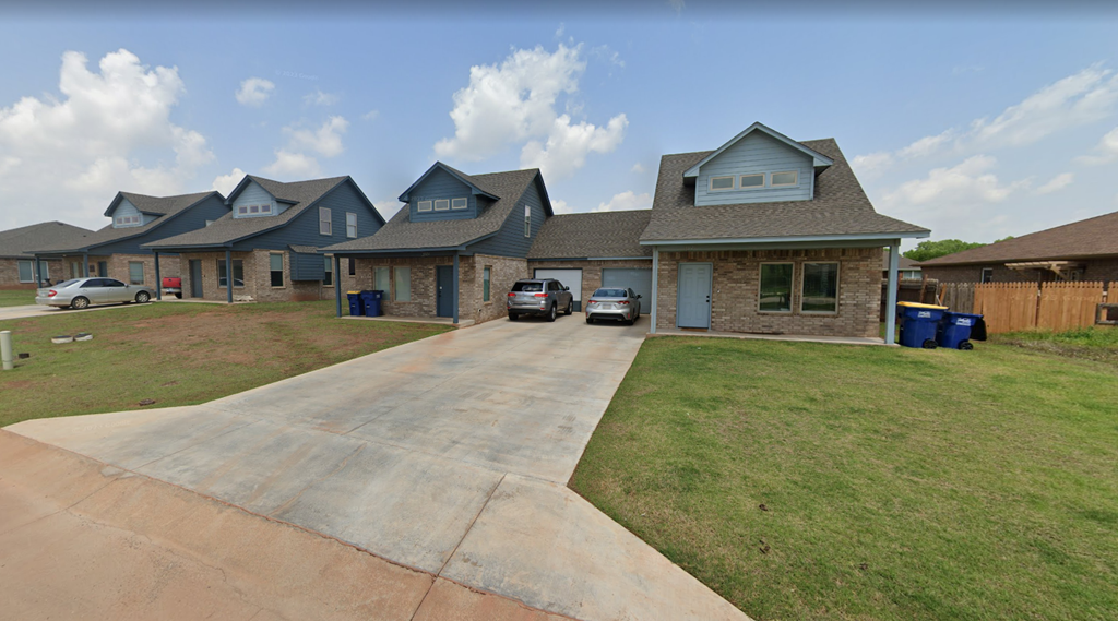 a house with a driveway and cars parked in front of it
