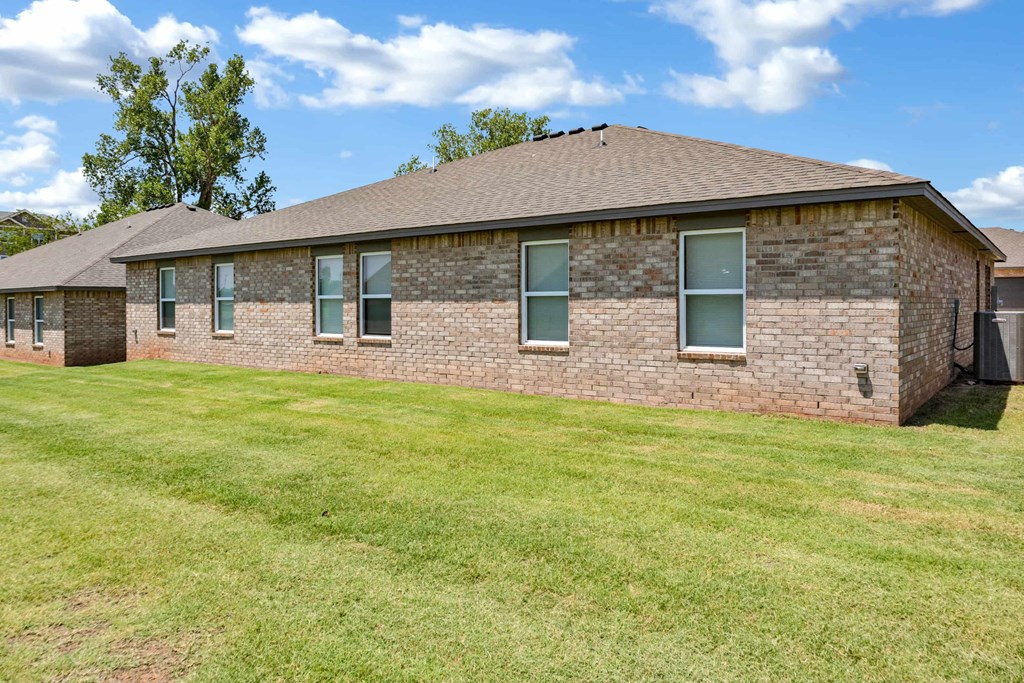 a brick house with green grass in front of it