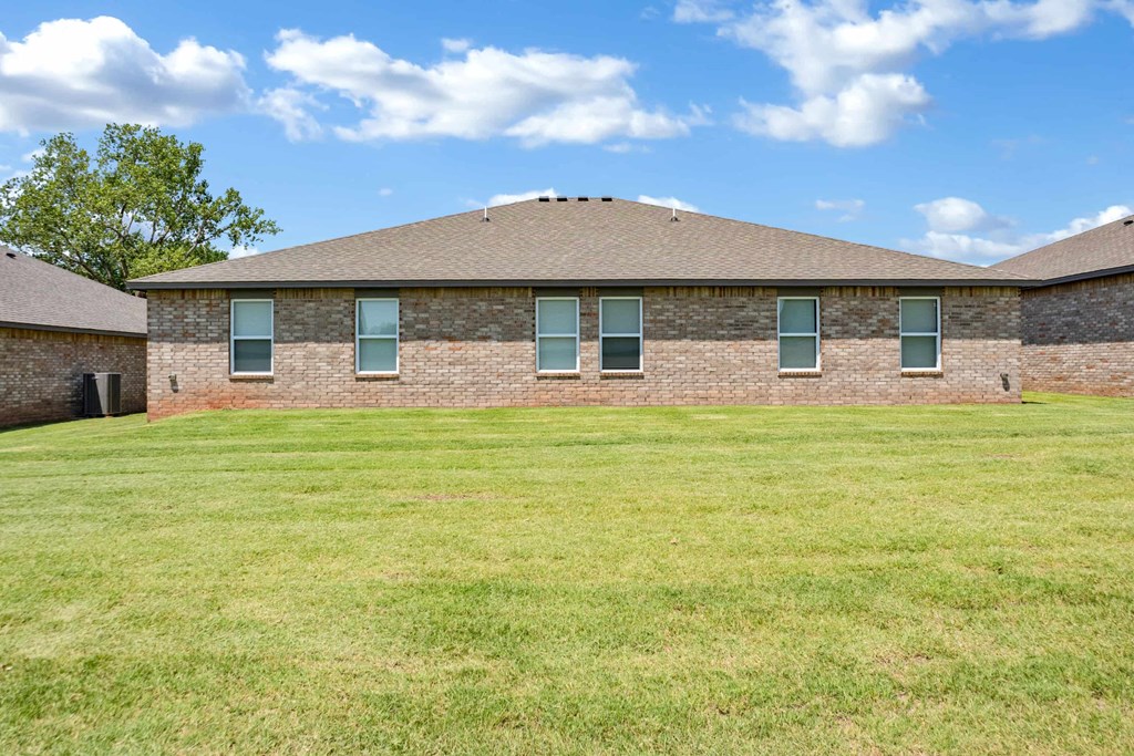 a brick house with green grass in front of it