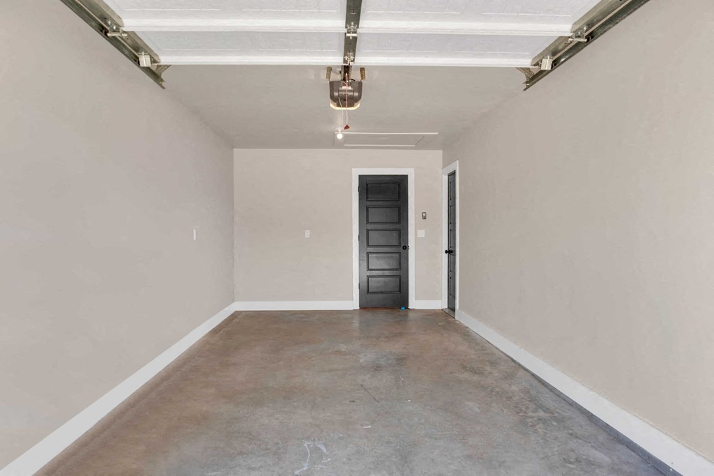 a empty garage with a black door and white walls