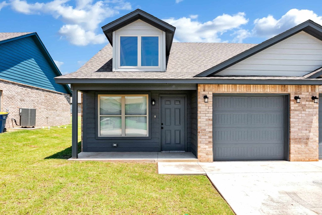 a house with two garage doors and a sidewalk in front of it