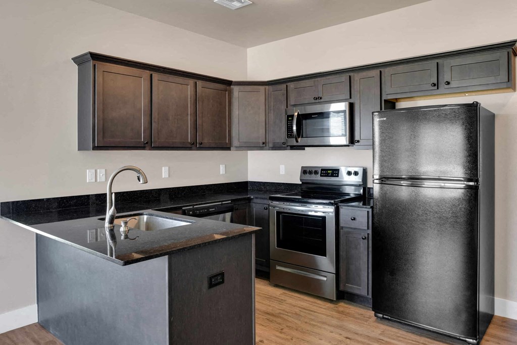 a kitchen with stainless steel appliances and dark wood cabinets