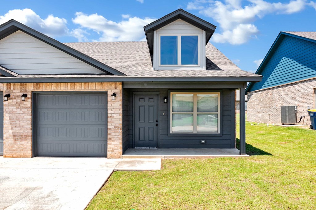 a house with two garage doors and a sidewalk in front of it