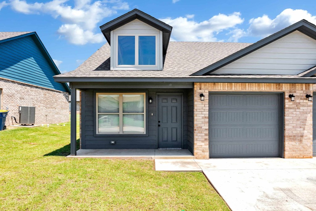 a house with two garage doors and a sidewalk in front of it