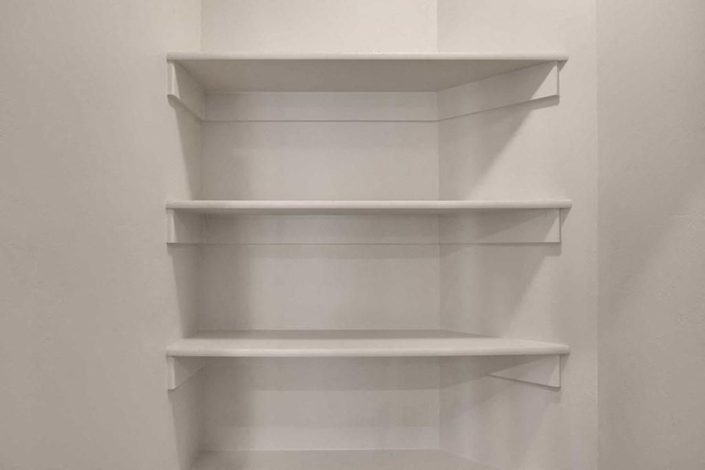 three white shelves on a wall in a room