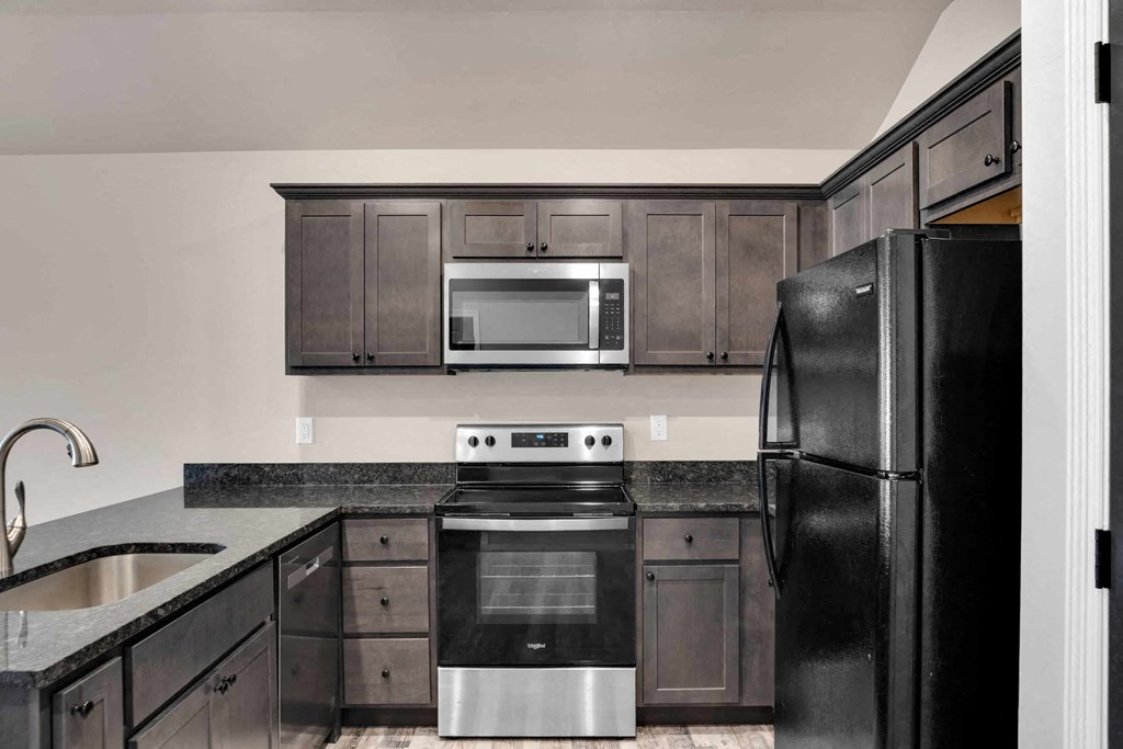 a kitchen with black appliances and a black refrigerator