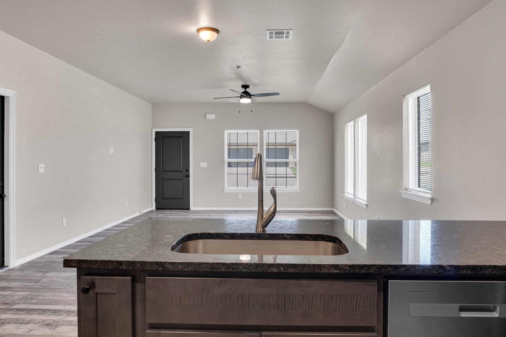 an empty kitchen with a sink in the middle of it