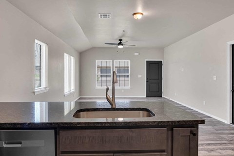 an empty kitchen with a sink in the center of it