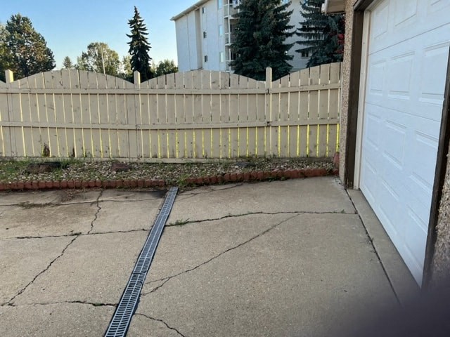 a yard with a white fence and a garage door