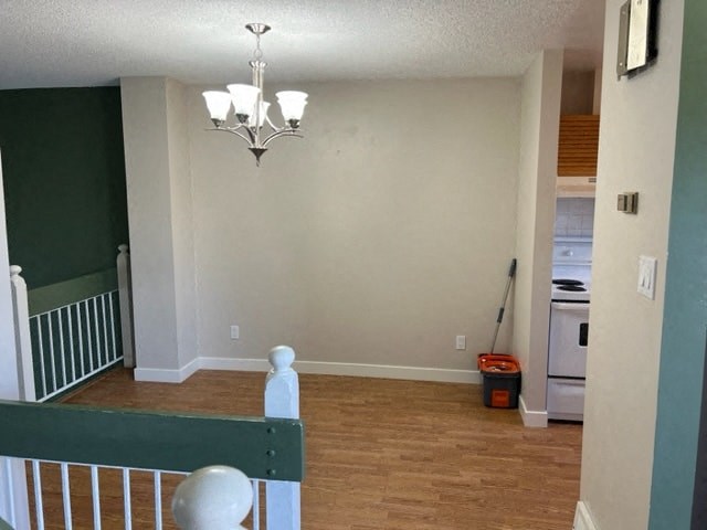 an empty living room with a staircase and a chandelier