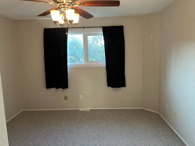 an empty room with a ceiling fan and curtains