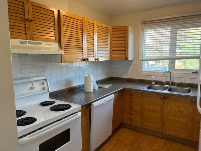 a kitchen with a stove and sink and wooden cabinets