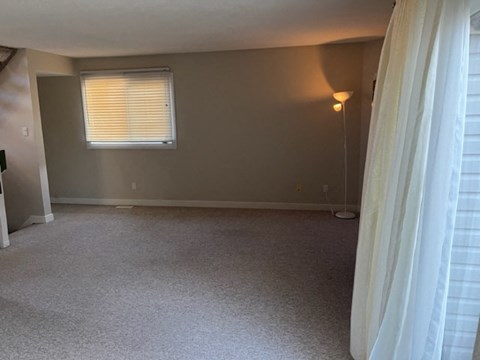 a living room with a window and a curtain