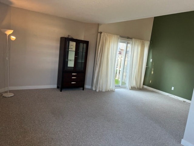 an empty living room with a dresser and a window
