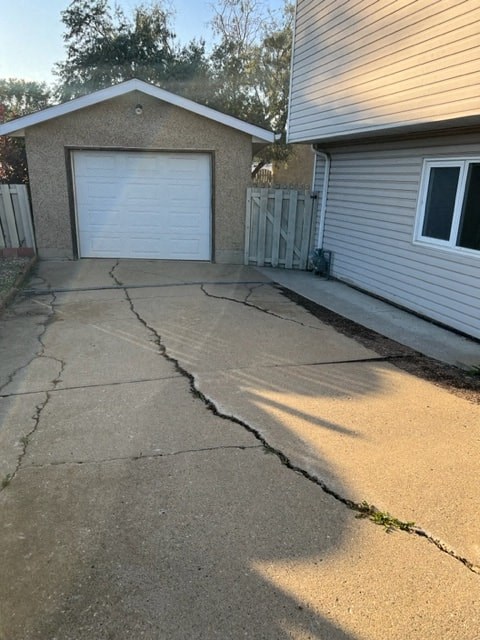 a cracked driveway in front of a house