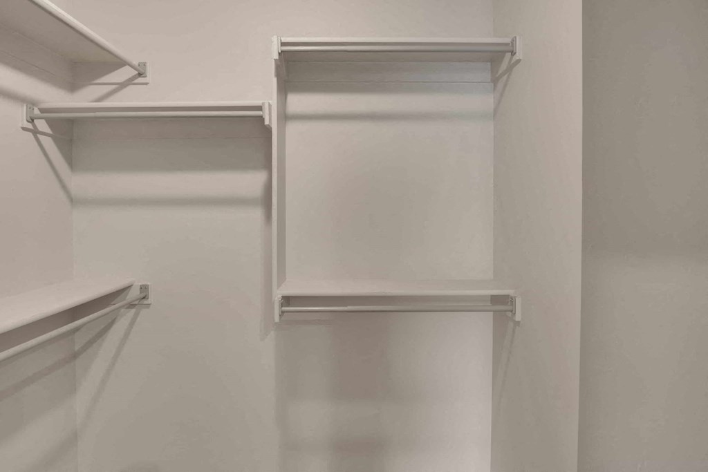 a white closet with white shelving and white walls