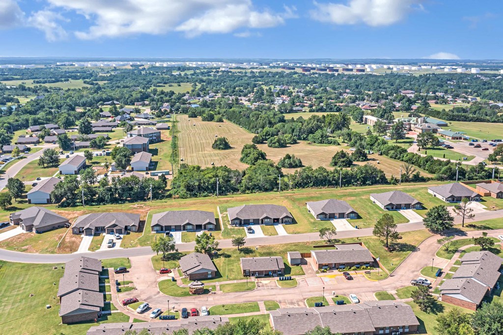 an aerial view of a neighborhood of houses with fields and trees