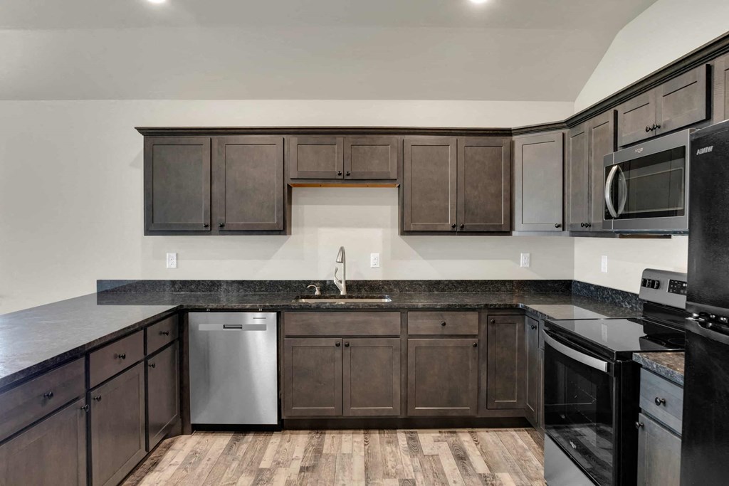 a kitchen with dark wood cabinets and stainless steel appliances