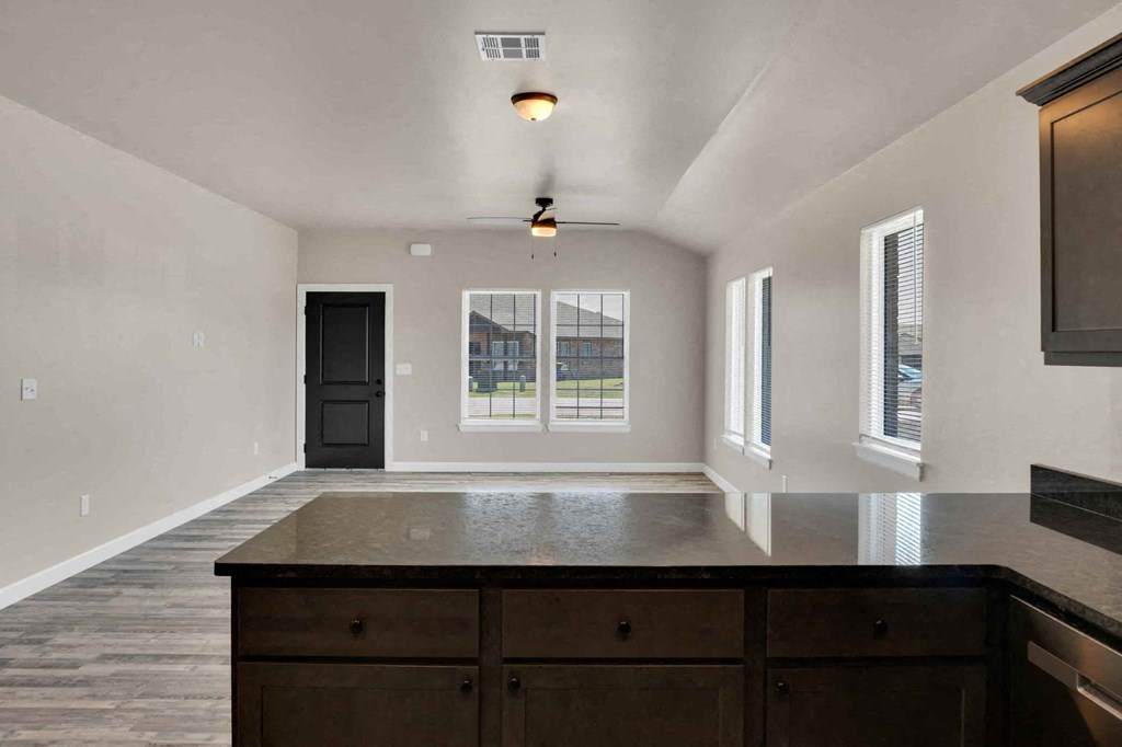 an empty living room with a counter top in front of a window