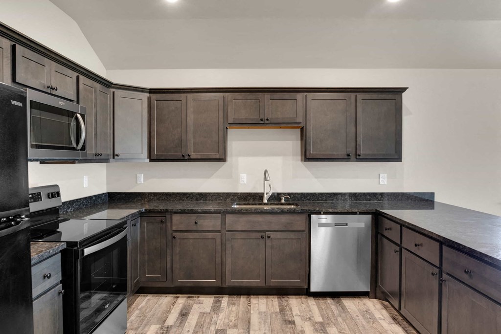 a kitchen with dark wood cabinets and stainless steel appliances