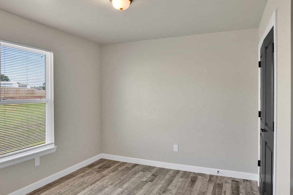 an empty room with a window and a door