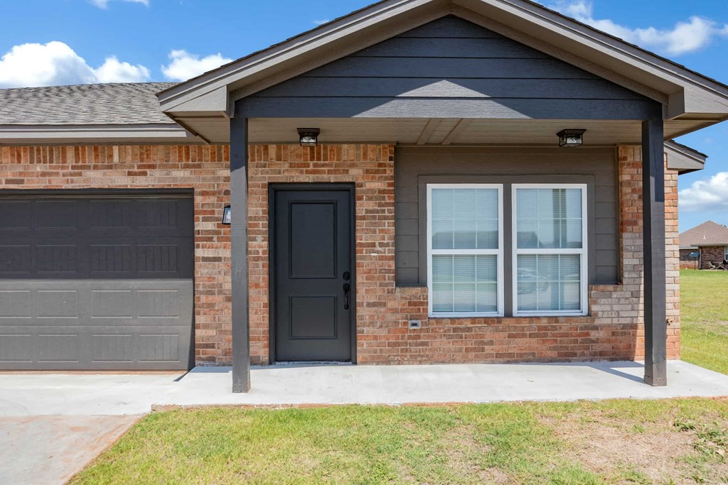 the front of a brick house with a black door