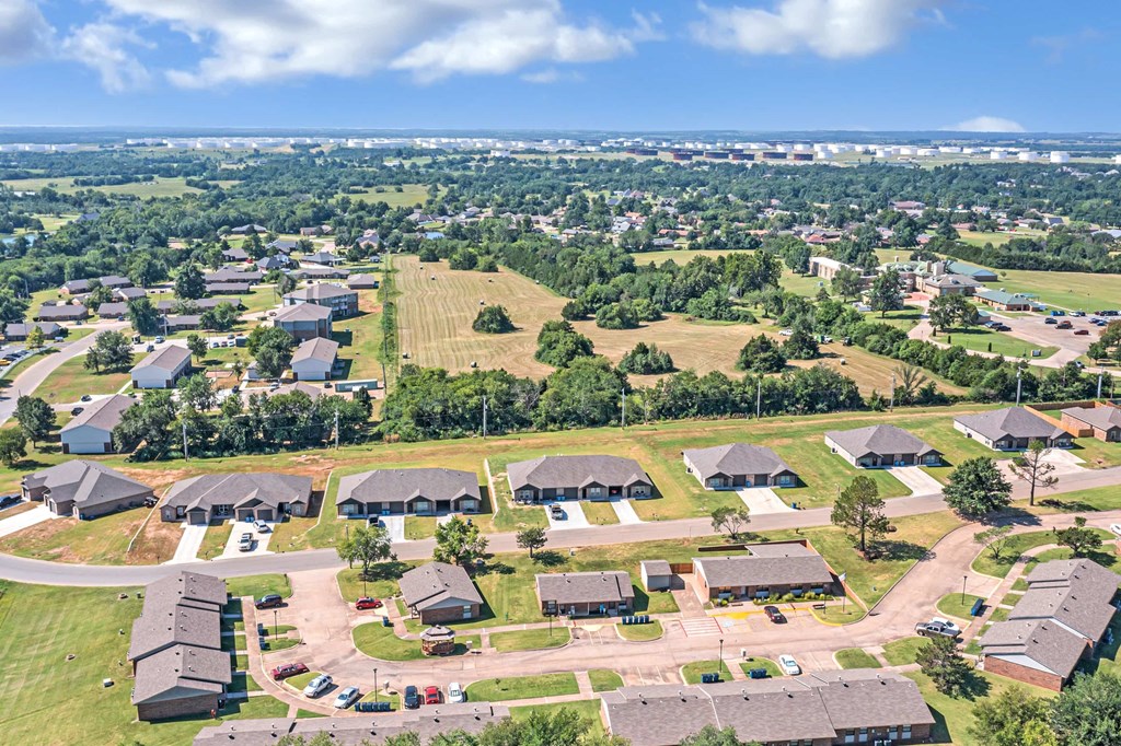 an aerial view of a neighborhood of houses with fields and trees