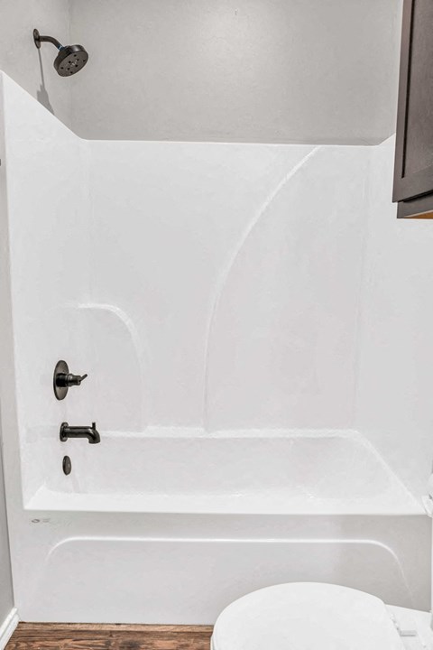 a small bathroom with a white tub and a toilet