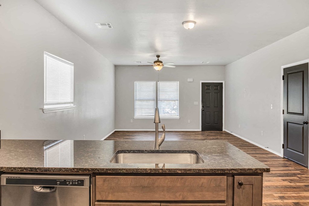 an empty kitchen with a sink and a door to a hallway