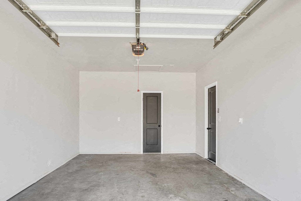 an empty room with a door and a ceiling light